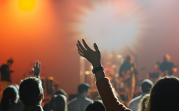 Crowd with hands lifted up and bright light at a worship service